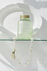 Deutschland, Bayern, München, Alte Zuckerflasche mit Perlenkette hinter Schaufenster - LFF000464
