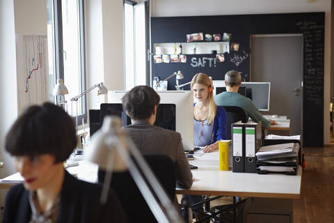 Germany, Cologne, Men and women working in office stock photo