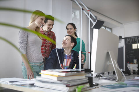 Deutschland, Köln, Männer und Frauen bei der Arbeit im Büro, lizenzfreies Stockfoto
