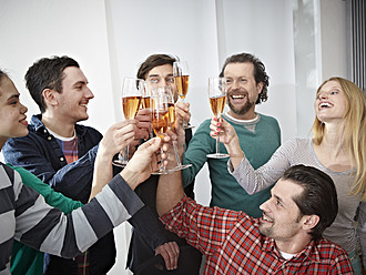 Germany, Cologne, Men and women toasting with champagne in office - RHYF000070