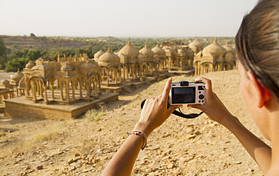 Indien, Rajasthan, Jaisalmer, Weibliche Touristin fotografiert bei Bada Bagh Cenotaphs - MBEF000315