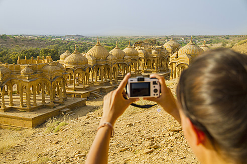 Indien, Rajasthan, Jaisalmer, Weibliche Touristin fotografiert bei Bada Bagh Cenotaphs - MBEF000316