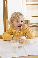 Girl eating boiled egg in breakfast, eating egg - RNF000857