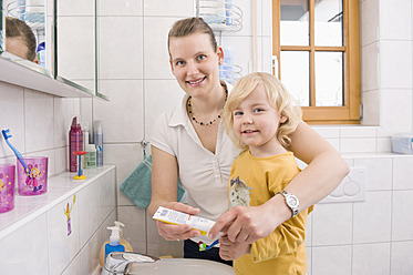 Mother helping daughter for brushing teeth, smiling, portrait - RNF000954
