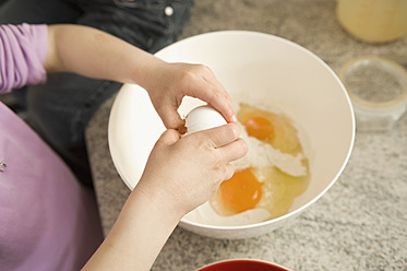 Girl breaking egg in bowl - RNF000900