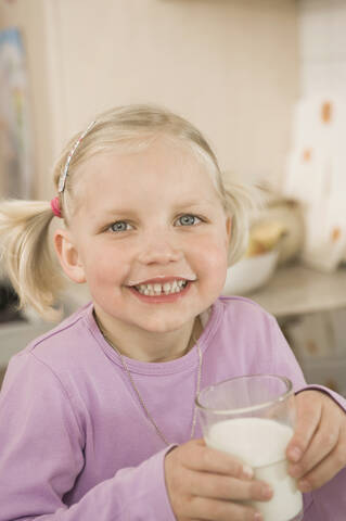 Mädchen trinkt ein Glas Milch, lächelnd, Porträt, lizenzfreies Stockfoto