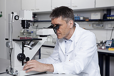 Germany, Bavaria, Munich, Scientist with microscope in laboratory - RBF000815