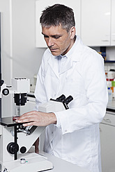 Germany, Bavaria, Munich, Scientist with microscope in laboratory - RBF000817