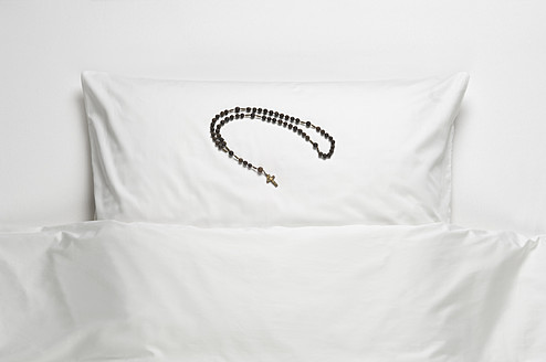 Rosenkranzperlen auf dem Bett - CRF002192