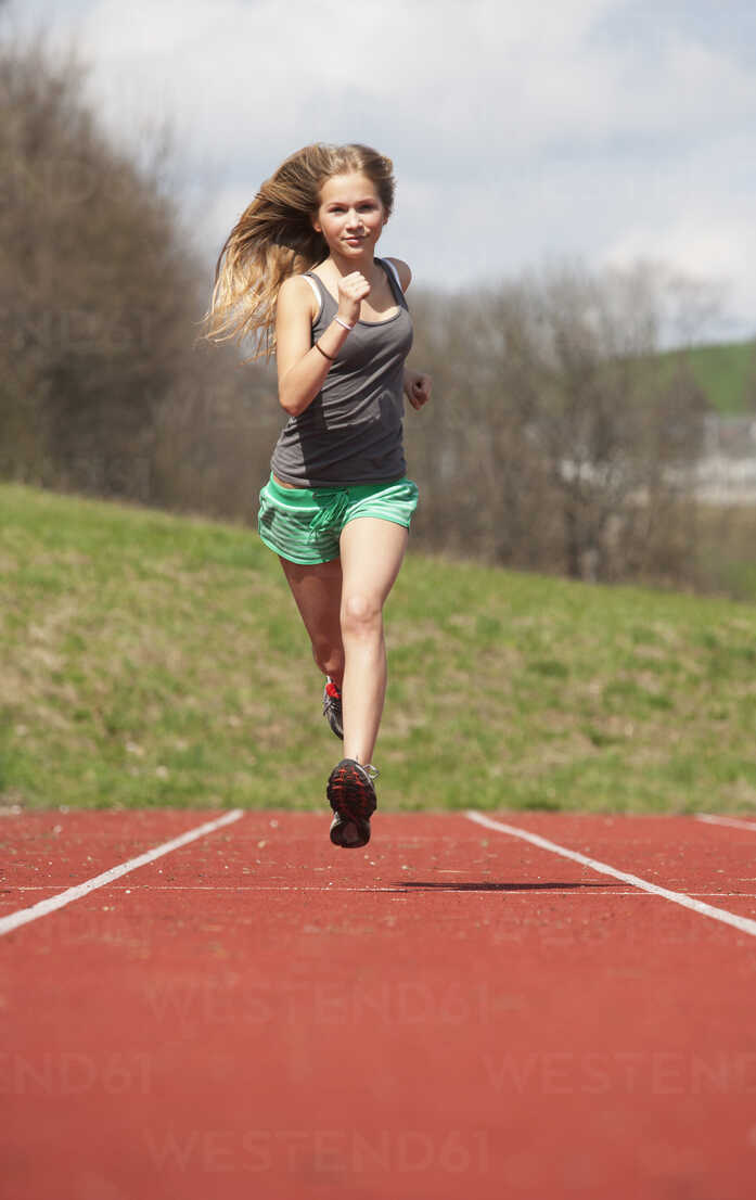 Austria, Teenage girl running on track, portrait stock photo