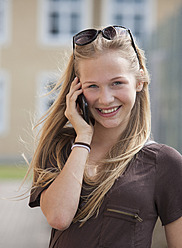 Österreich, Jugendliches Mädchen am Handy, lächelnd, Porträt - WWF002320