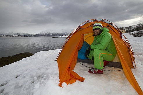 Norway, Lyngen, Skier in tent near polar sea - FFF001306