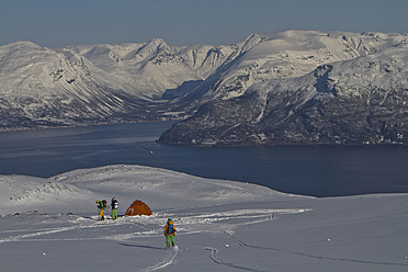 Norwegen, Männer stehen am Zelt auf verschneitem Land - FFF001297