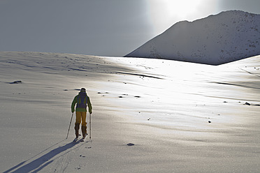 Norwegen, Lyngen, Skifahrer stehend auf verschneitem Land - FFF001296