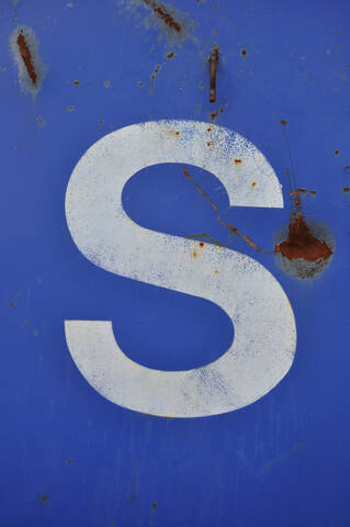 Weißer Sprühlack Buchstabe S auf Blau, Nahaufnahme, lizenzfreies Stockfoto
