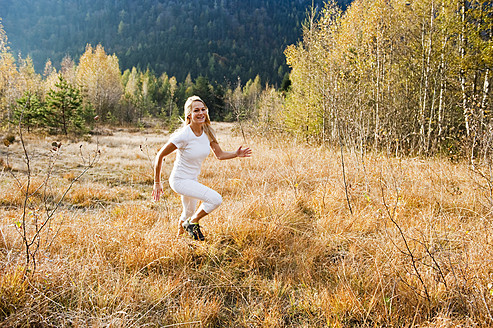 Austria, Salzburg, Young woman running in autumn - HHF004167