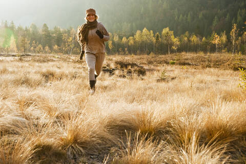 Austria, Salzburg, Young woman running in autumn stock photo