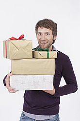 Mittlerer erwachsener Mann mit Weihnachtsgeschenken, lächelnd, Porträt - BMYF000203