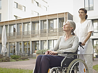 Germany, Cologne, Caretaker pushing senior women in wheelchair - WESTF018663