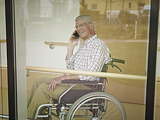 Deutschland, Köln, Älterer Mann am Telefon im Pflegeheim, lächelnd - WESTF018666