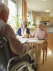 Germany, Cologne, Men on wheelchair with women sitting in nursing home - WESTF018681