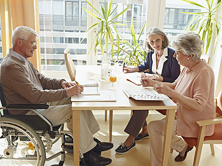 Deutschland, Köln, Männer im Rollstuhl mit Frauen im Pflegeheim sitzend - WESTF018682