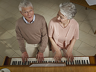 Germany, Cologne, Senior couple playing piano in nursing home - WESTF018705