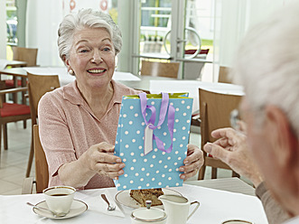 Deutschland, Köln, Ältere Frau übergibt Geschenk an Mann - WESTF018707