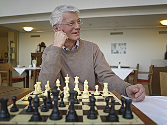 Deutschland, Köln, Älterer Mann spielt Schach im Pflegeheim - WESTF018717
