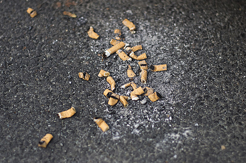 Deutschland, Frankfurt, Zigarettenstummel auf der Straße - MUF001198