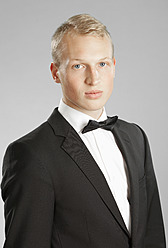 Junger Mann im schwarzen Anzug vor grauem Hintergrund - MAEF004658