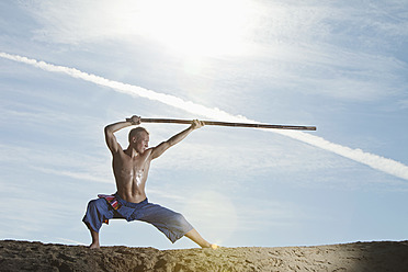 Germany, Bavaria, Young man doing martial arts training with stick - MAEF004662