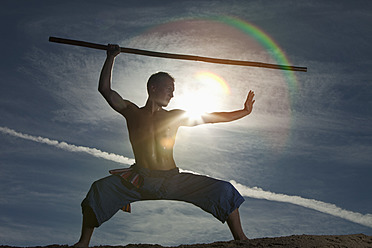 Germany, Bavaria, Young man doing martial arts training with stick - MAEF004665