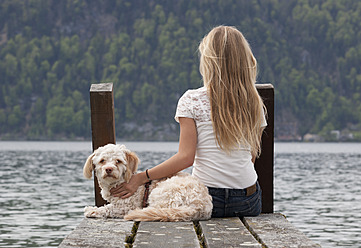 Österreich, Jugendliches Mädchen mit Hund auf Steg - WWF002382
