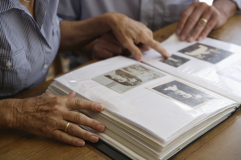 Germany, Bavaria, Senior couple with photo album - TCF002572