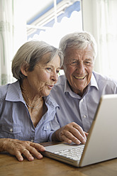 Deutschland, Bayern, Älteres Paar benutzt Laptop zu Hause - TCF002594