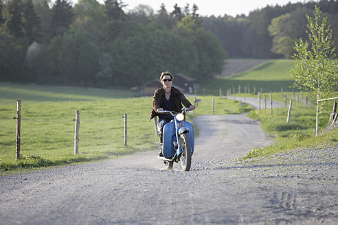 Deutschland, Bayern, Ältere Frau fährt altes Moped der 1960er Jahre - TCF002602