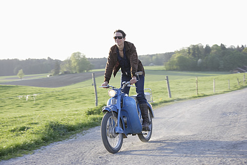 Deutschland, Bayern, Ältere Frau fährt altes Moped der 1960er Jahre - TCF002601