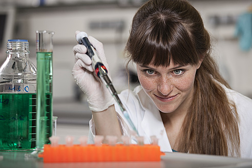 Deutschland, Bayern, München, Wissenschaftlerin mit Pipette und Reagenzgläsern im Labor - RBF000864