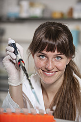 Germany, Bavaria, Munich, Scientist with pipette and test tubes in laboratory - RBF000865