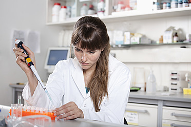 Germany, Bavaria, Munich, Scientist with pipette and test tubes in laboratory - RBF000885