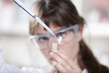 Germany, Bavaria, Munich, Scientist with pipette and test tube in laboratory - RBF000888