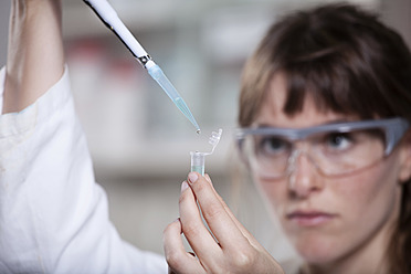 Germany, Bavaria, Munich, Scientist with pipette and test tube in laboratory - RBF000889