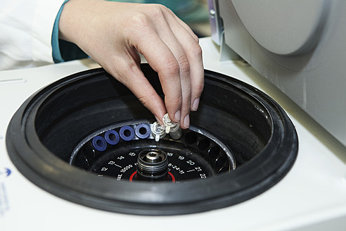 Germany, Bavaria, Munich, Human hand loading test tubes into small centrifuge - RBF000906