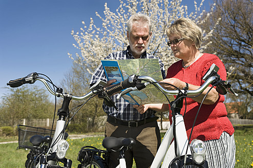 Germany, Bavaria, Senior couple watching road map - RNF000944