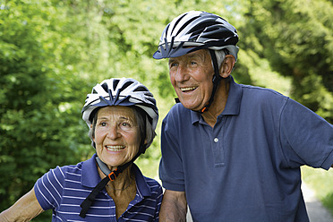 Deutschland, Bayern, Seniorenpaar mit Fahrradhelm, lächelnd - TCF002635