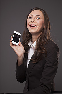 Geschäftsfrau mit Mobiltelefon, lächelnd, Porträt - PRAF000023