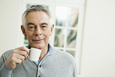 Germany, Berlin, Senior man with coffee cup, portrait - FMKYF000005