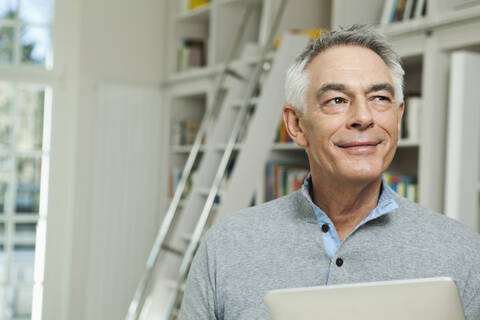 Germany, Berlin, Senior man with tablet pc, smiling stock photo