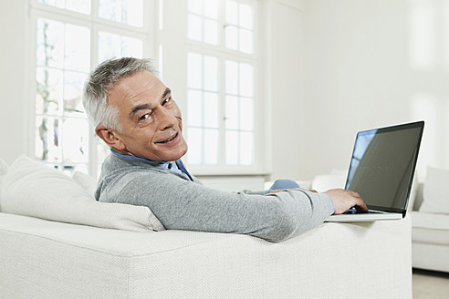 Deutschland, Berlin, Senior Mann mit Laptop, Porträt - FMKYF000020